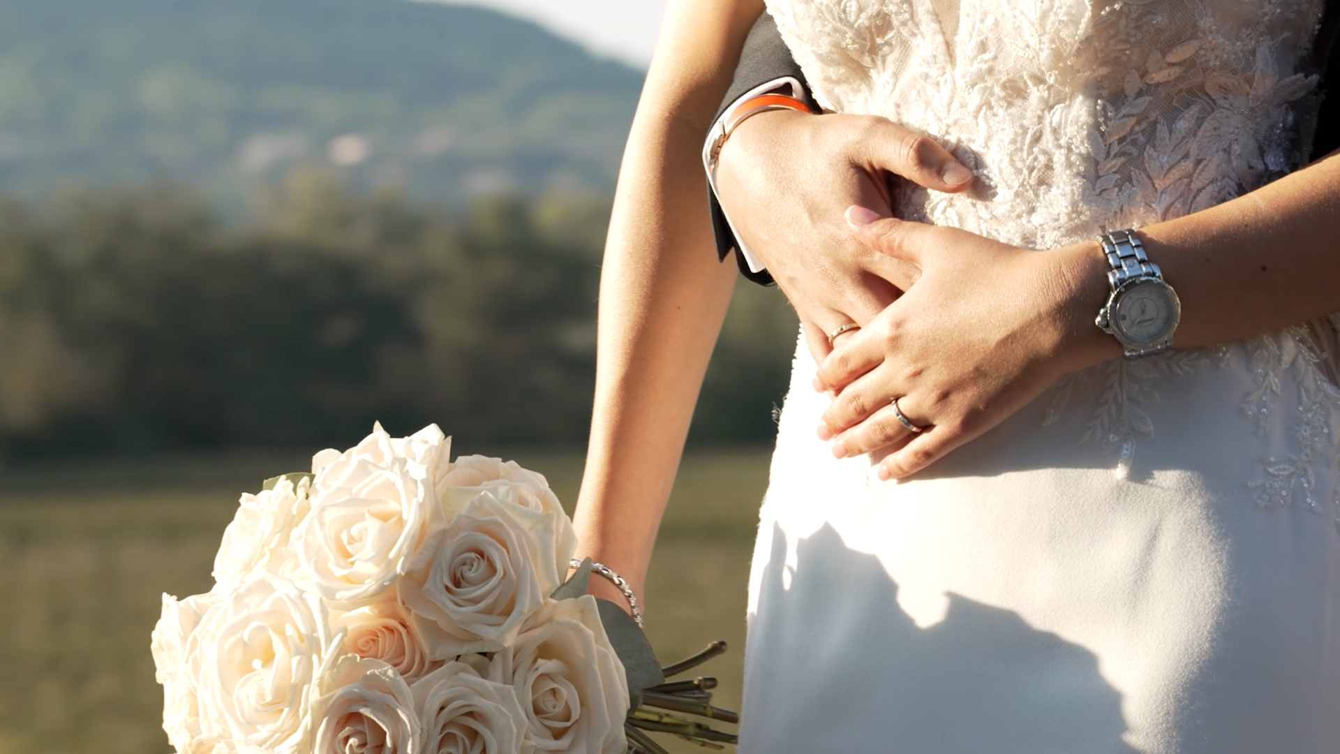 Les mains des mariés et le bouquet de roses blanches